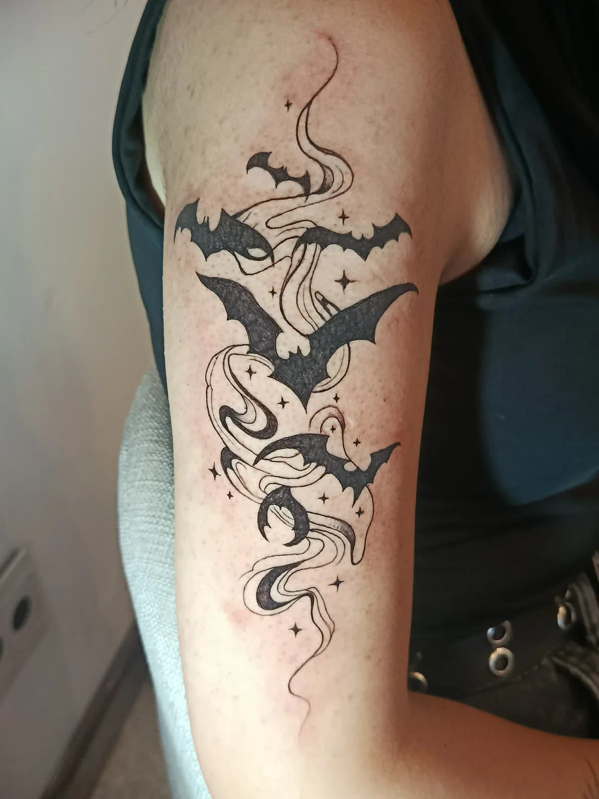 Tatuagem blackwork com morcegos e elementos ornamentais na coxa.