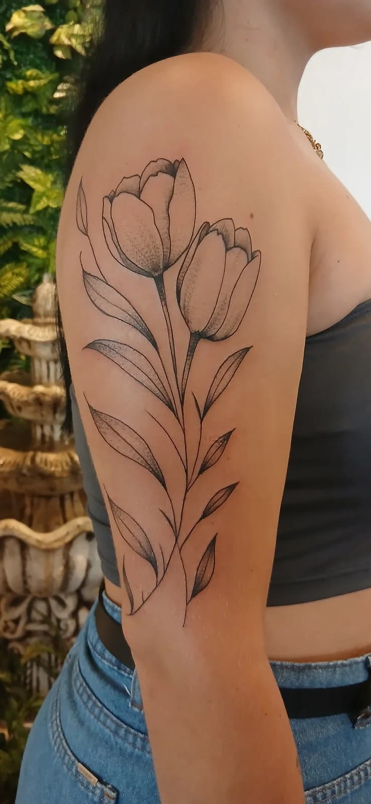 Tatuagem botânica minimalista no braço.