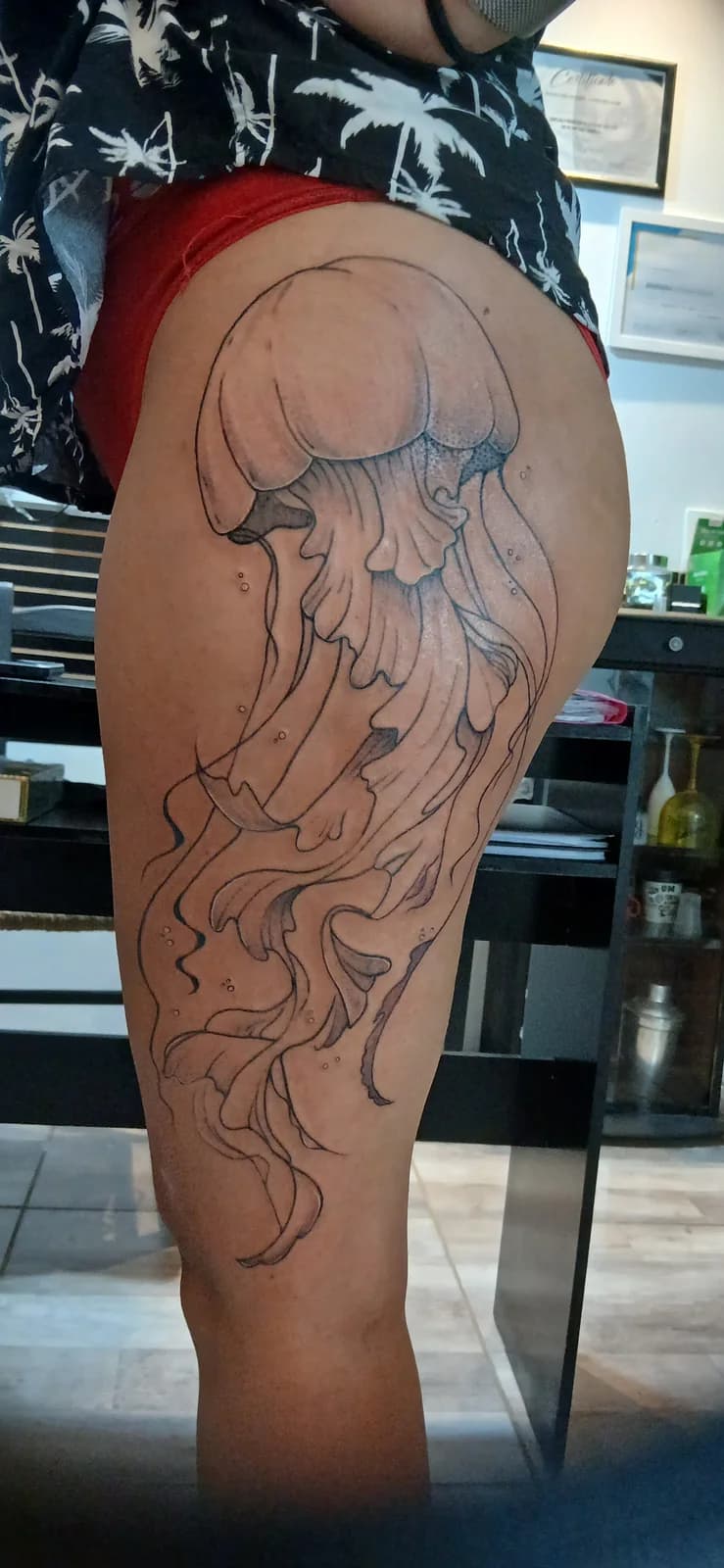 Tatuagem botânica em traço fino na perna.
