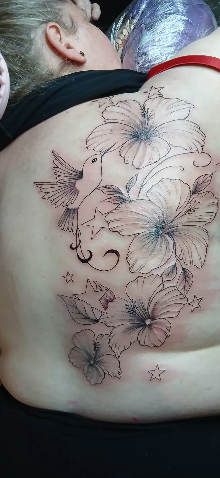 Tatuagem floral ampla nas costas.