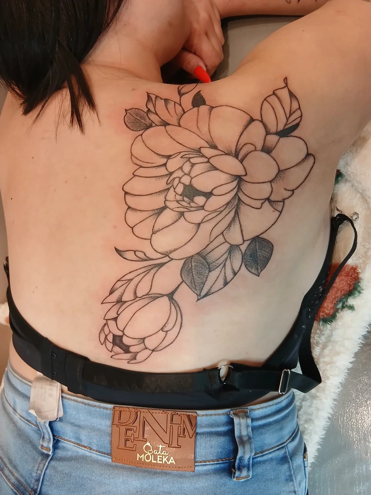 Tatuagem floral autoral nas costas.