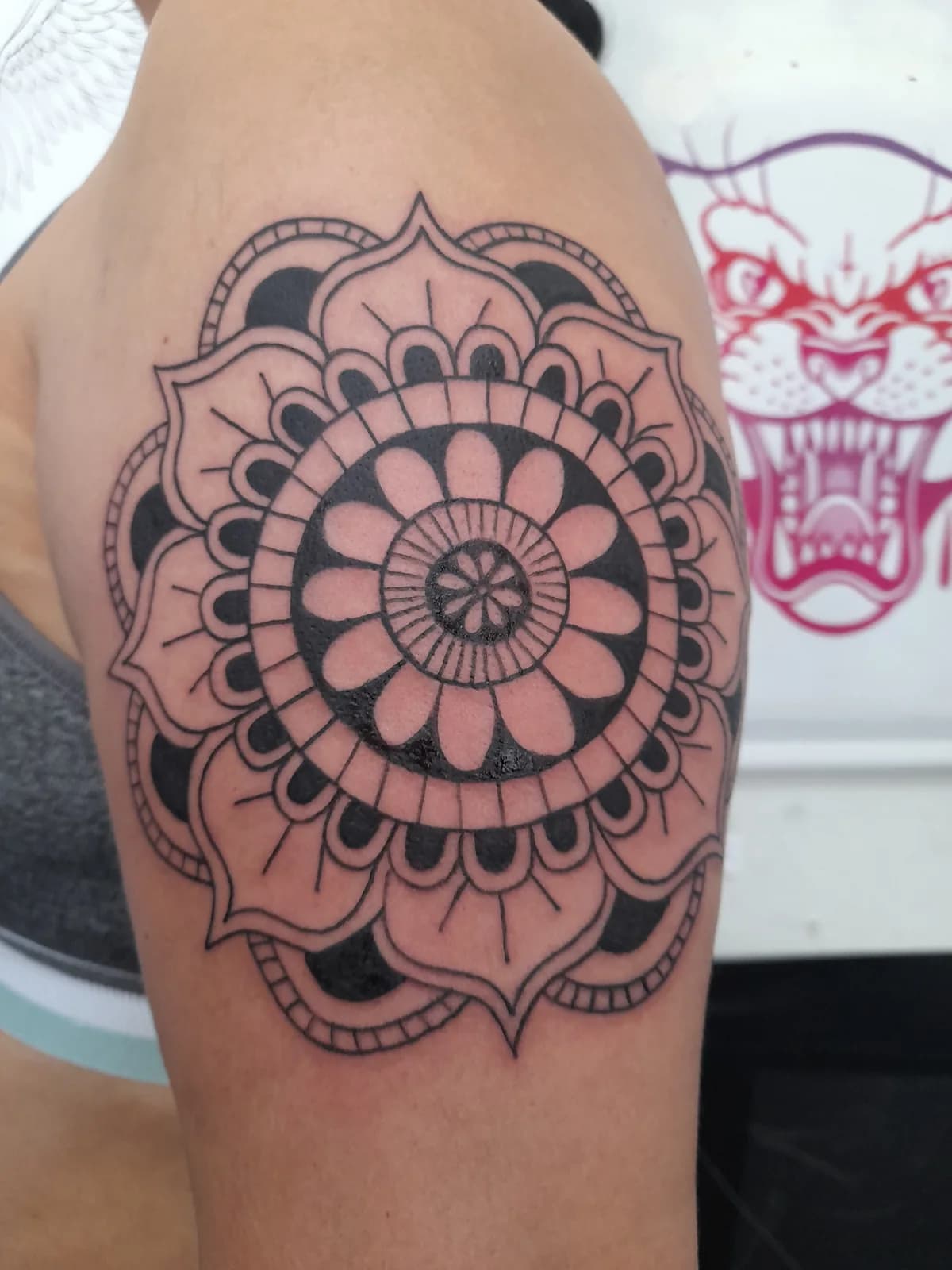 Tatuagem de mandala ornamental em preto.